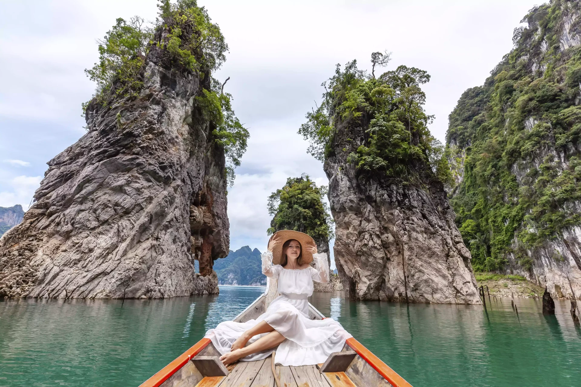 travel-woman-sitting-boat-near-famous-three-rocks-khao-sok-park-thailand